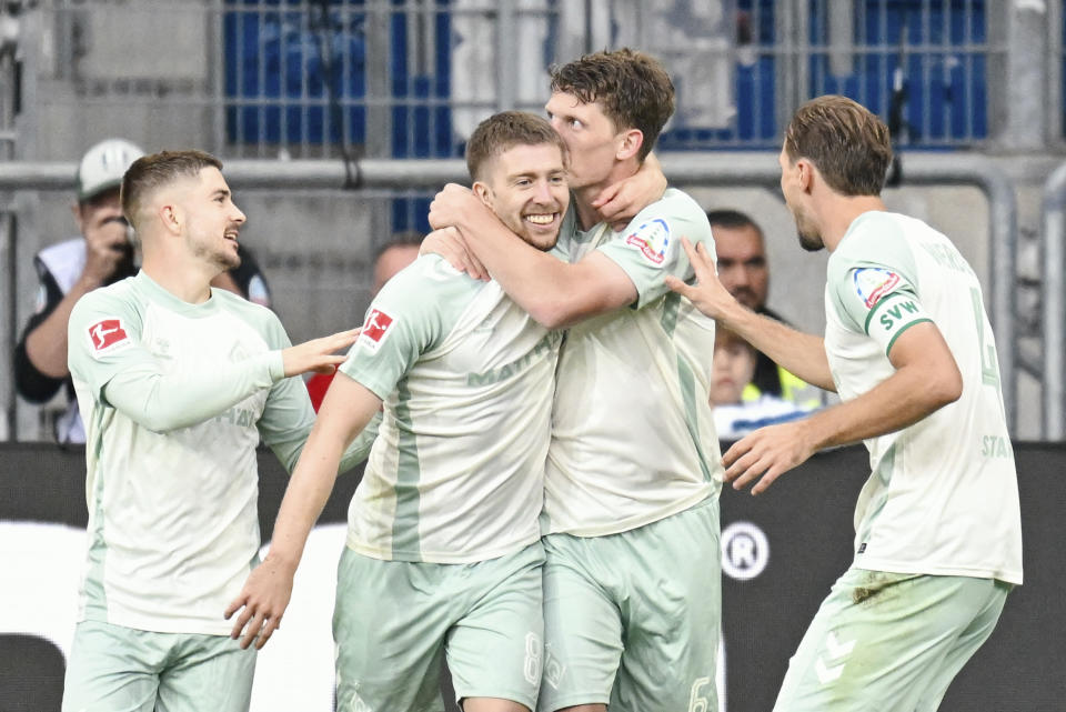 Bremen's Jens Stage, second from left, celebrates with teammates after scoring his side's fourth goal during the Bundesliga soccer match between TSG 1899 Hoffenheim and Werder Bremen, at the PreZero Arena in Sinsheim, Germany, Sunday, Sept. 29, 2024. (Uwe Anspach/dpa via AP)