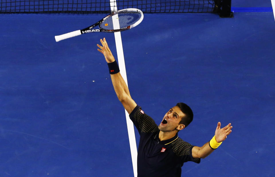 Novak Djokovic of Serbia celebrates defeating Andy Murray of Britain in their men's singles final match at the Australian Open tennis tournament in Melbourne January 27, 2013. Djokovic became the first man to win three successive Australian Open titles in the professional era. REUTERS/David Gray (AUSTRALIA - Tags: SPORT TENNIS TPX IMAGES OF THE DAY) - RTR3D16H