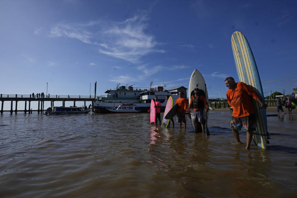 Surfers prepare to ride the tidal bore wave known as "Pororoca," during the Amazon Surf Festival held in the Canal do Perigoso, or "Dangerous Channel," at the mouth of the Amazon River near Chaves, Marajo Island archipelago, Para state, Brazil, Monday, June 5, 2023. The Pororoca, a word from an Amazonian Indigenous dialect that means "destroyer" or "great blast," happens twice a day when the incoming ocean tide reverses the river flow for a time. (AP Photo/Eraldo Peres)