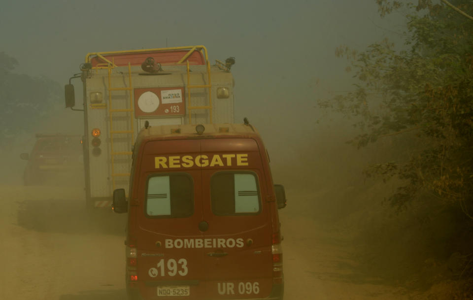 A line of fire fighting vehicles advance through smoke from forest fires in the Vila Nova Samuel region, along the road to the National Forest of Jacunda, near to the city of Porto Velho, Rondonia state, part of Brazil's Amazon, Sunday, Aug. 25, 2019. Leaders of the Group of Seven nations said Sunday they were preparing to help Brazil fight the fires burning across the Amazon rainforest and repair the damage even as tens of thousands of soldiers were being deployed to fight the blazes that have caused global alarm. (AP Photo/Eraldo Peres)