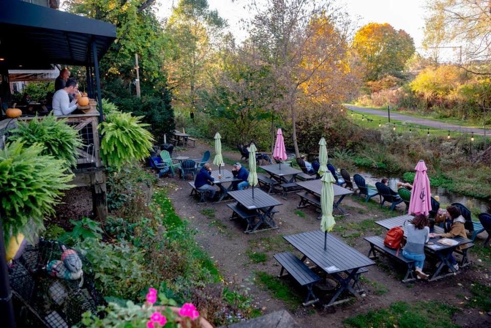 Customers have drinks and food by the creek at Voodoo Brewery in State College on Tuesday, October. 24, 2023. Abby Drey/adrey@centredaily.com
