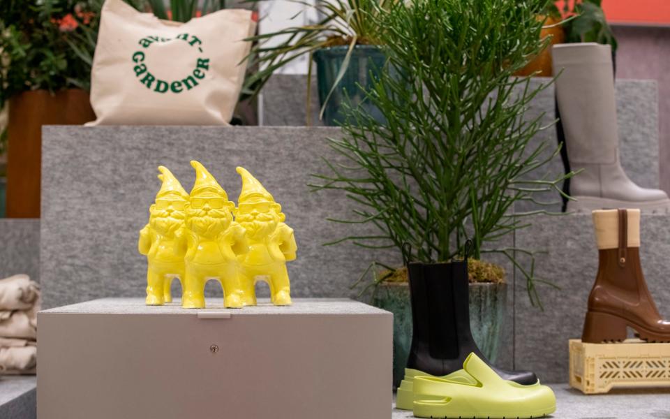 A golden trio of gnomes form part of a display at the garden centre, along with trendy printed tote bags - Rii Schroer