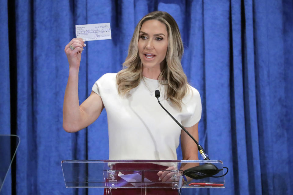 FILE - Lara Trump, the newly-elected co-chair of the Republican National Committee, holds up a donation check as she gives an address during the general session of the RNC Spring Meeting Friday, March 8, 2024, in Houston. “My number one goal is making sure that Donald Trump is the 47th president,” Trump said in an interview with The Associated Press. (AP Photo/Michael Wyke, File)
