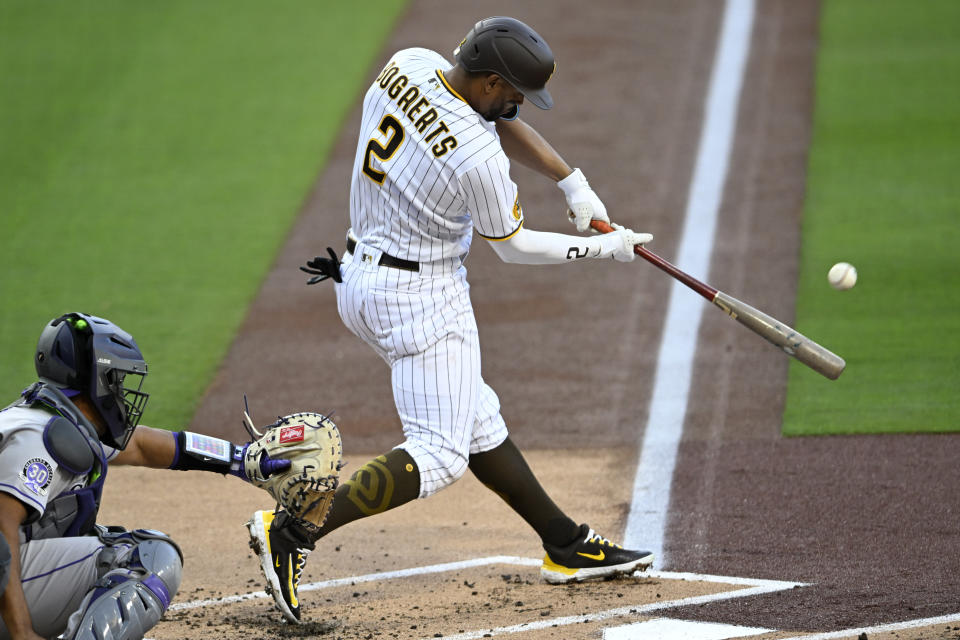 San Diego Padres' Xander Bogaerts hits a two-run home run next to Colorado Rockies catcher Elias Diaz during the first inning of a baseball game in San Diego, Saturday, April 1, 2023. (AP Photo/Alex Gallardo)