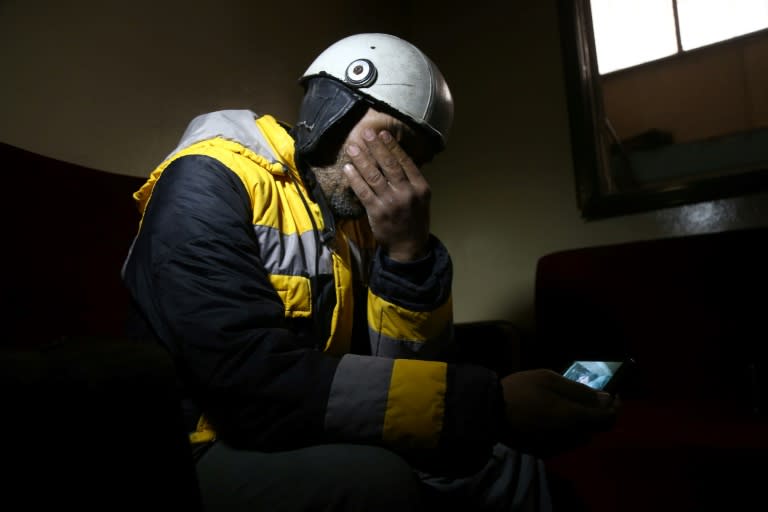 Rescuer Samir Salim mourns as he holds a picture that he took as he tried to retrieve his mother's body from under the rubble of his home in Syria's rebel-held Eastern Ghouta