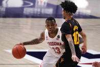 Arizona guard James Akinjo (13) drives against Arizona State guard Jaelen House during the first half of an NCAA college basketball game, Monday, Jan. 25, 2021, in Tucson, Ariz. (AP Photo/Rick Scuteri)