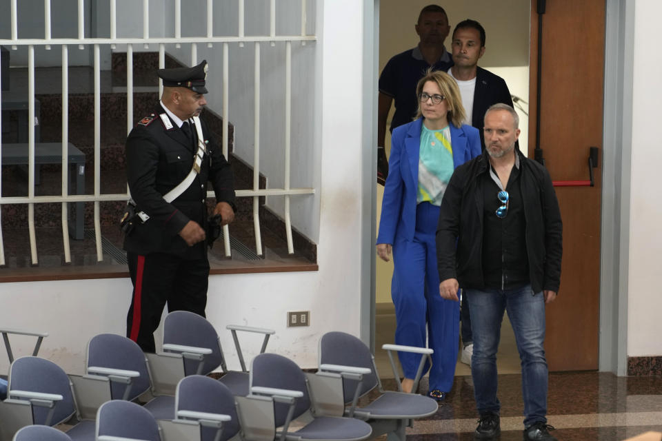 Prosecuting Magistrate Carmen Ruggiero is escorted by plain clothes police as she enters the in bunker hall of Lecce, Italy, before the start of an audience, Wednesday, May 22, 2024. In the past few months, Carmen Ruggiero, the prosecutor leading the team against a clan in a case known as "Operation Wol." was threatened by a jailed mafioso. (AP Photo/Alessandra Tarantino)