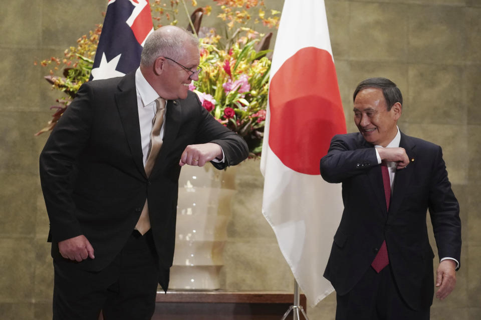 Australian Prime Minister Scott Morrison, left, greets Japanese Prime Minister Yoshihide Suga prior to the official welcome ceremony at Suga's official residence in Tokyo Tuesday, Nov. 17, 2020. Morrison is in Japan to hold talks with Suga to bolster defense ties between the two U.S. allies to counter China’s growing assertiveness in the Asia-Pacific region. (AP Photo/Eugene Hoshiko, Pool)