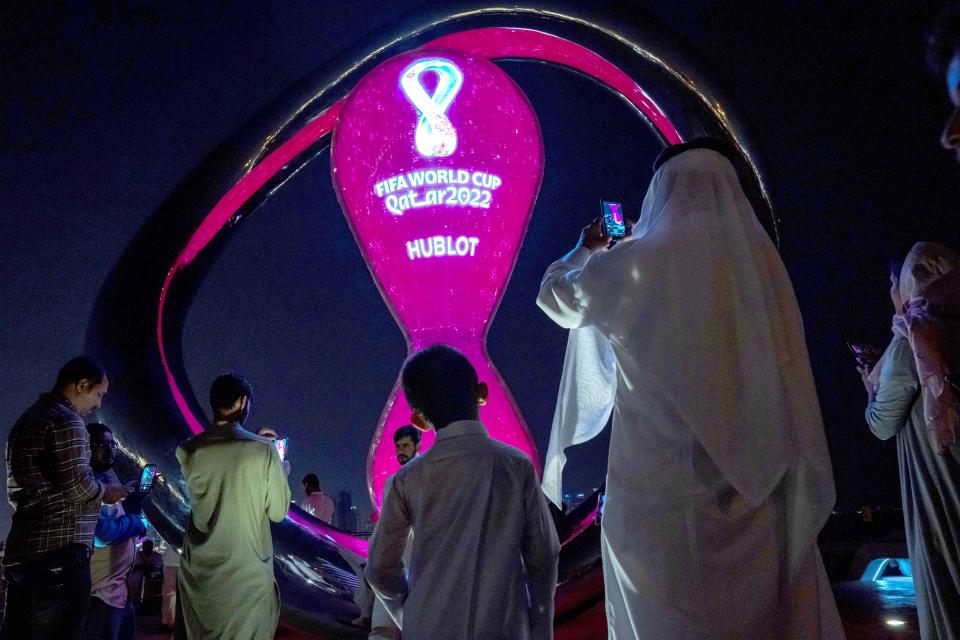 FILE - People take photos with the official FIFA World Cup Countdown Clock on Doha's corniche, in Qatar, Friday, Oct. 14, 2022. Hosting the World Cup marks a pinnacle in Qatar's efforts to rise out of the shadow of its larger neighbors in the wider Middle East. (AP Photo/Nariman El-Mofty, File)