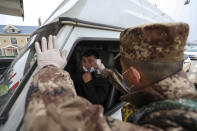 A militia member uses a digital thermometer to take a driver's temperature at a checkpoint at a highway toll gate in Wuhan in central China's Hubei Province, Thursday, Jan. 23, 2020. China closed off a city of more than 11 million people Thursday in an unprecedented effort to try to contain a deadly new viral illness that has sickened hundreds and spread to other cities and countries amid the Lunar New Year travel rush. (Chinatopix via AP)