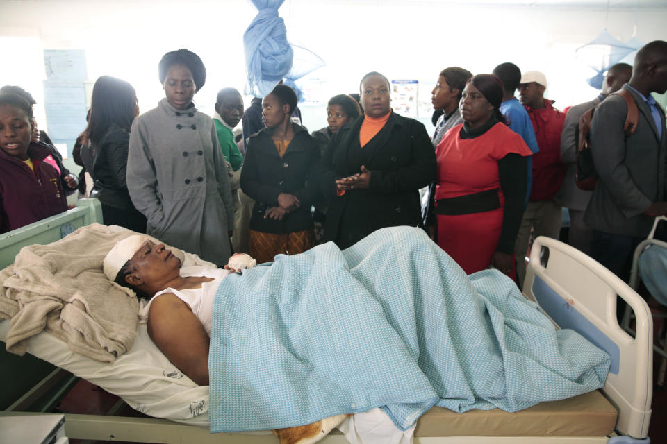 A woman who survived a bus crash receives treatment in Rusape about 170 kilometres east of the capital Harare, Thursday, Nov. 8, 2018. A head-on collision between two buses has killed 47 people, where road accidents are common due to poor roads and bad driving. (AP Photo/Tsvangirayi Mukwazhi)