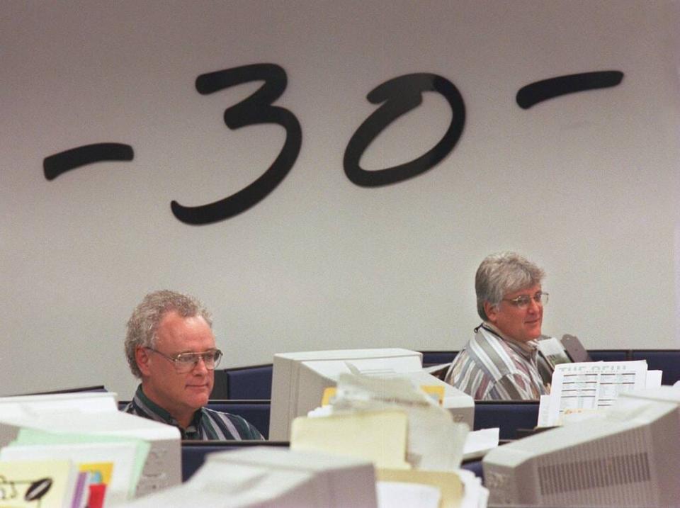 Ledger sports writer Mike Cobb, left, and Executive Sports Editor John Valerino work in the newsroom on deadline in 1998, shortly after moving into the new building. The -30- on the wall is an old journalistic symbol once placed at the end of stories