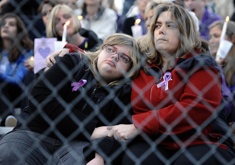 A woman and child hold hands as they sit on the bleachers during a vigil for Maren Sanchez at Jonathan Law High School, Monday, April 28, 2014, in Milford, Conn. Sanchez was fatally stabbed inside the school on Friday hours before her junior prom. (AP Photo/Jessica Hill)