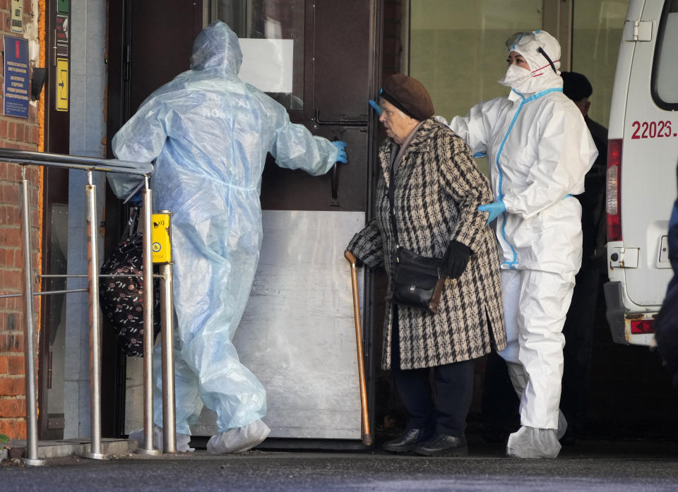 Medical workers accompany a patient suspected of having coronavirus at a hospital for COVID-19 patients in St. Petersburg, Russia, Friday, Oct. 29, 2021. Russia on Friday recorded another record of daily coronavirus deaths as authorities hoped to stem contagion by keeping most people off work. (AP Photo/Dmitri Lovetsky)