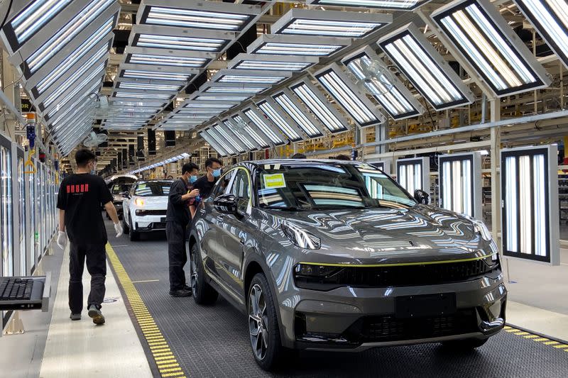 FILE PHOTO: Employees wearing face masks work on a Lynk &Co car production line at Geely's Yuyao plant in Ningbo