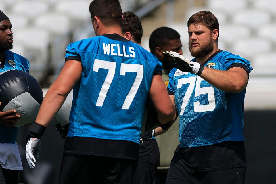 Jacksonville Jaguars guard Cooper Hodges (75) high-fives tackle Josh Wells (77) during an organized team activity on May 30 at EverBank Field.