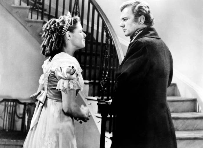 Ingrid Bergman and Joseph Cotten talking at the bottom of the stairs.