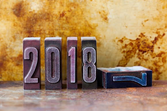 A metallic brick with numerical 7 etched on it lying beside four bricks with 2018 etched on them.