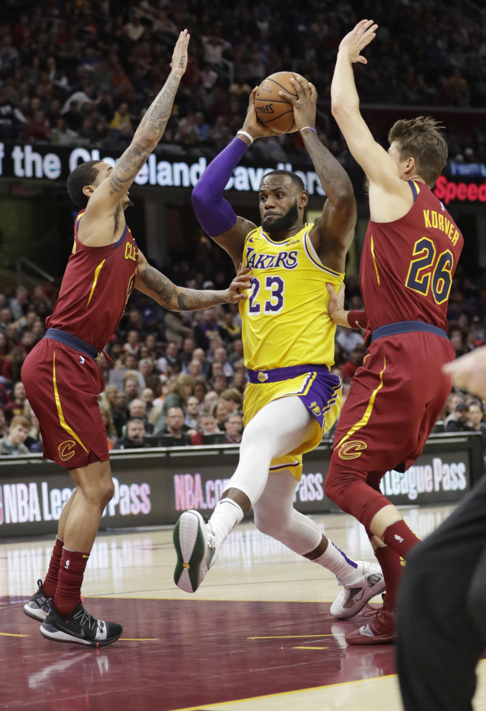 Los Angeles Lakers' LeBron James (23) drives between Cleveland Cavaliers' Jordan Clarkson, left, and Kyle Korver (26) during the second half of an NBA basketball game Wednesday, Nov. 21, 2018, in Cleveland. The Lakers won 109-105. (AP Photo/Tony Dejak)