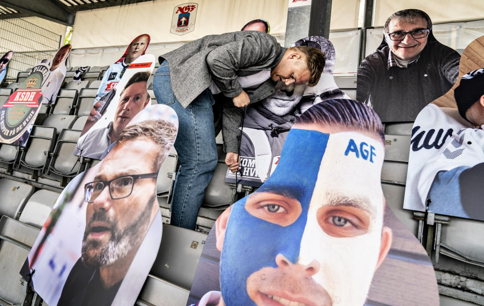 Pictures of soccer fans are placed in the stands as Ceres Park Football Stadium gets ready for the Danish Superliga match between AGF and Randers FC in Aarhus, Denmark, Wednesday May 27, 2020. FC Midtjylland and AGF Aarhus have gotten creative as they look to generate some atmosphere because games have to be played in empty stadiums. Midtjylland is planning a “drive-in” where about 2,000 supporters can watch games from inside their cars in a parking lot outside the team’s stadium. Aarhus is installing three giant screens along one side of the field displaying the faces of about 10,000 fans on a live video call. The first match of the Danish Superliga will be played Thursday evening May 28 in Aarhus. (Henning Bagger/Ritzau scanpix via AP)