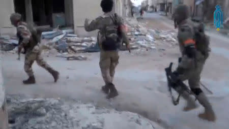 A still image taken from a video uploaded on social media on March 22, 2017, purports to show Tahrir al-Sham rebel fighters running with their weapons, said to be in Soran district, near Hama, Syria. Social Media Website via Reuters TV