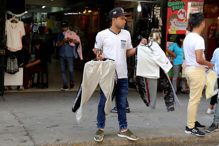 A migrant from Venezuela, sells clothing at Gamarra textile cluster in Lima's district of La Victoria in Lima, Peru, May 10, 2018. REUTERS/Guadalupe Pardo