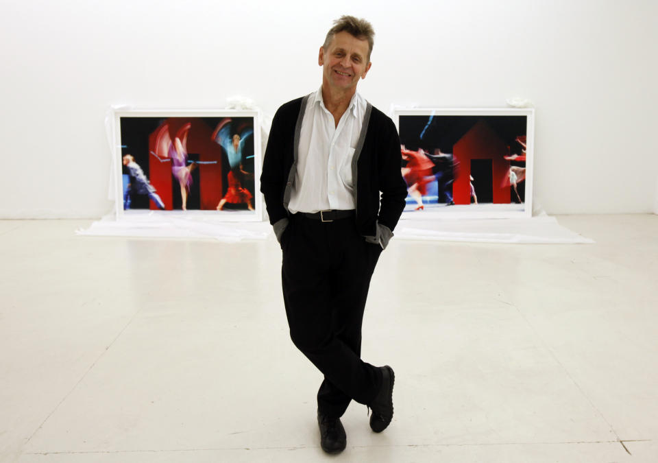 In this Tuesday, Feb. 21, 2012 photo, dancer Mikhail Baryshnikov, poses with two of the photographs he will be exhibiting at the Gary Nader Art Centre in Miami. The show, which opens Friday, Feb. 24, is titled “Dance This Way” and features large-scale photographs of ethnic, hip-hop, ballet, modern and popular dances performed on stage by professionals and in nightclubs by amateurs. (AP Photo/Wilfredo Lee)