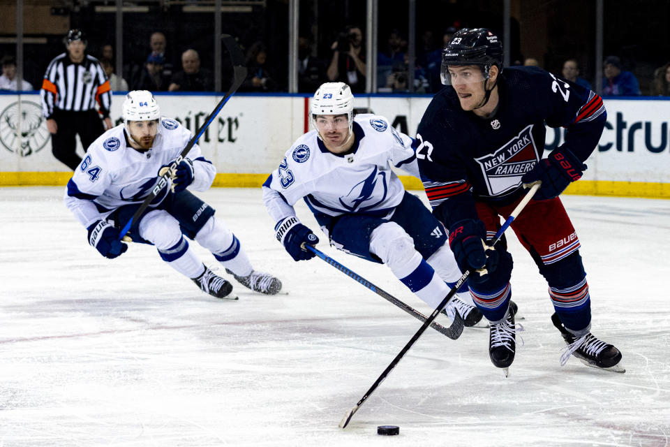 New York Rangers defenseman Adam Fox (23) looks to pass while pursued by Tampa Bay Lightning center Michael Eyssimont (23) and center Tyler Motte (64) during the first period of an NHL hockey game on Wednesday, Feb. 7, 2024 in New York. (AP Photo/Peter K. Afriyie)