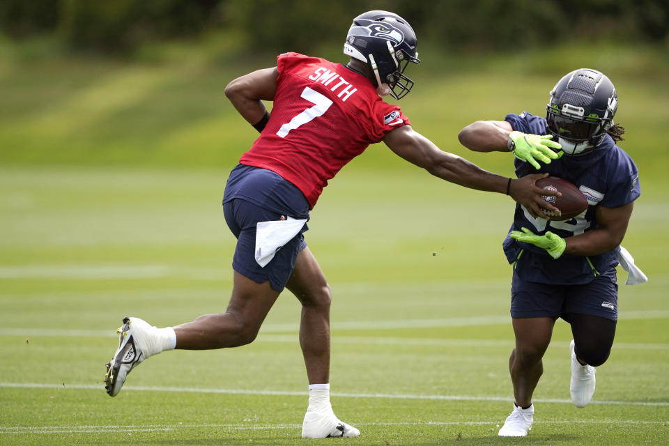 Seattle Seahawks quarterback Geno Smith (7) hands off to running back Josh Johnson, right, during NFL football practice Wednesday, June 8, 2022, in Renton, Wash. (AP Photo/Ted S. Warren)