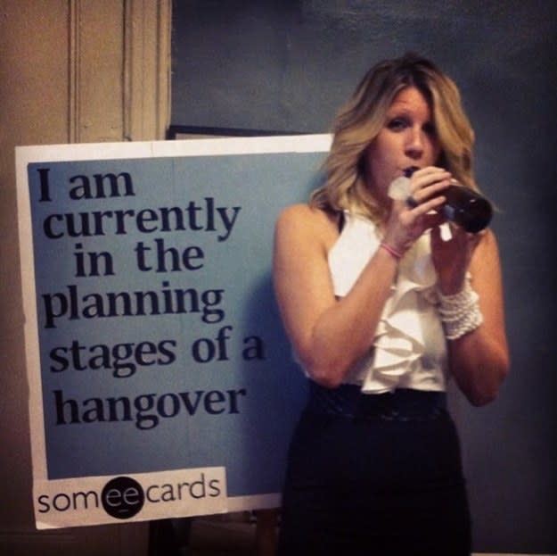 girl drinking with a sign that says "I am currently in the planning stages of a hangover"