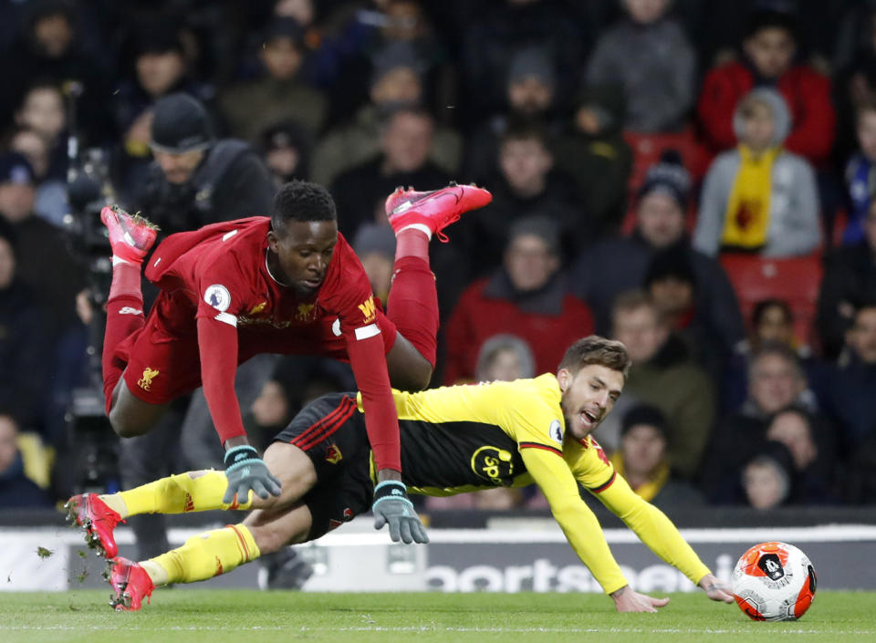 Liverpool's Divock Origi, left, duels for the ball with Watford's Kiko Femenia during the English Premier League soccer match between Watford and Liverpool at Vicarage Road stadium, in Watford, England, Saturday, Feb. 29, 2020. (AP Photo/Alastair Grant)