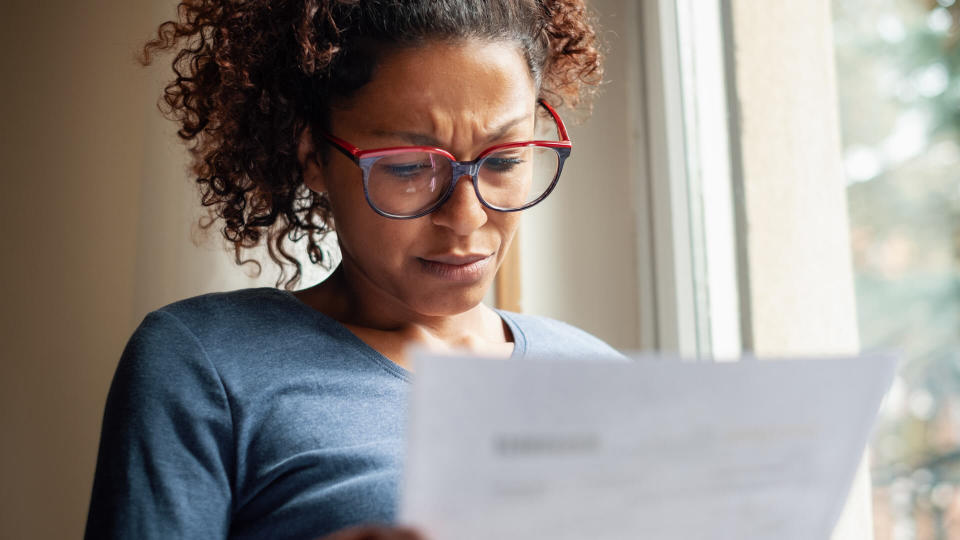 Portrait of worried black woman standing beside window.