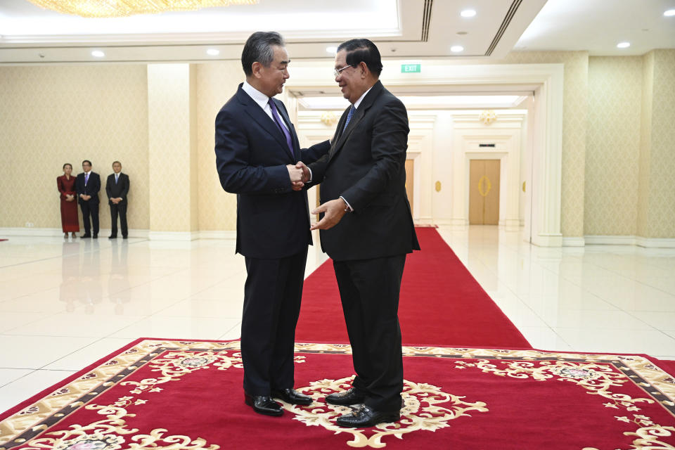 In this photo provided by Kok Ky/Cambodia's Government Cabinet, Cambodian Prime Minister Hun Sen, right, shakes hands with Chinese Foreign Minister Wang Yi during a meeting in Peace Palace in Phnom Penh, Cambodia, Sunday, Aug. 13, 2023. (Kok Ky/Cambodia's Government Cabinet via AP)