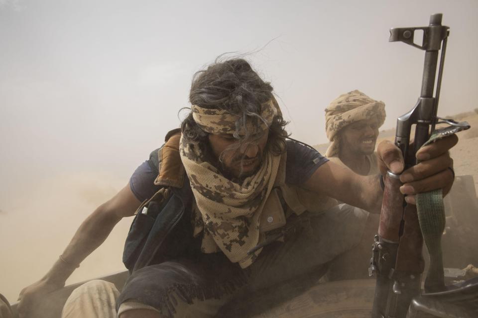 Yemeni fighters backed by the Saudi-led coalition ride on the back of an armored vehicle as they leave the front lines of Marib, Yemen, on June 19, 2021. (AP Photo/Nariman El-Mofty)