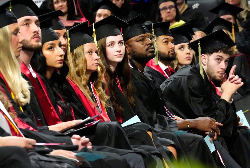 Graduates listen during commencement at University of Cincinnati at Fifth Third Arena, Friday, April 26, 2024. UC is awarded 4,549 bachelor's degrees, 539 associate degrees, 1,886 master's degrees and 252 doctoral degrees during the three-day commencement period.