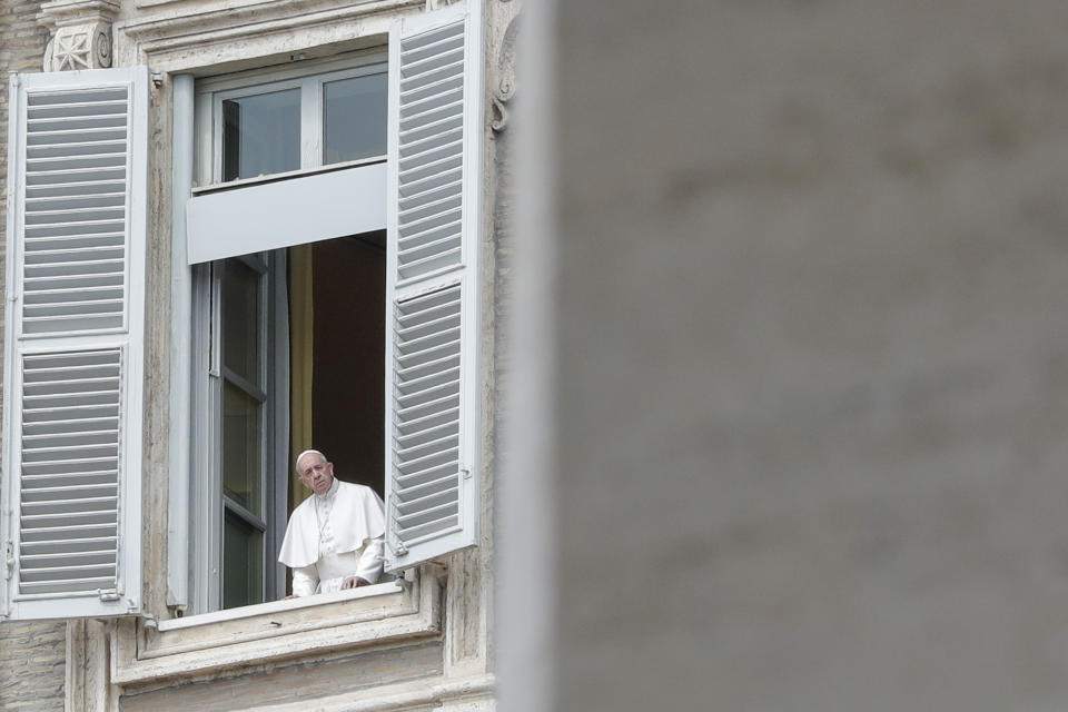 Pope Francis looks out during his noon blessing from the window of his studio overlooking an empty St. Peter's Square, due to anti-coronavirus lockdown measures, at the Vatican,, Monday, April 13, 2020. The new coronavirus causes mild or moderate symptoms for most people, but for some, especially older adults and people with existing health problems, it can cause more severe illness or death. (AP Photo/Andrew Medichini)