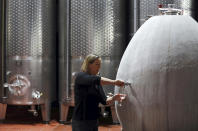 FILE - In this Wednesday, May 27, 2020 file photo, Cellar Master Elunda Basson works at the Steenberg vineyard in Constantia, Cape Town, South Africa. With wine-tasting tourists to the farms of the Western Cape Province drying up many wineries face a bleak future due to COVID-19. (AP Photo/Nardus Engelbrecht, File)