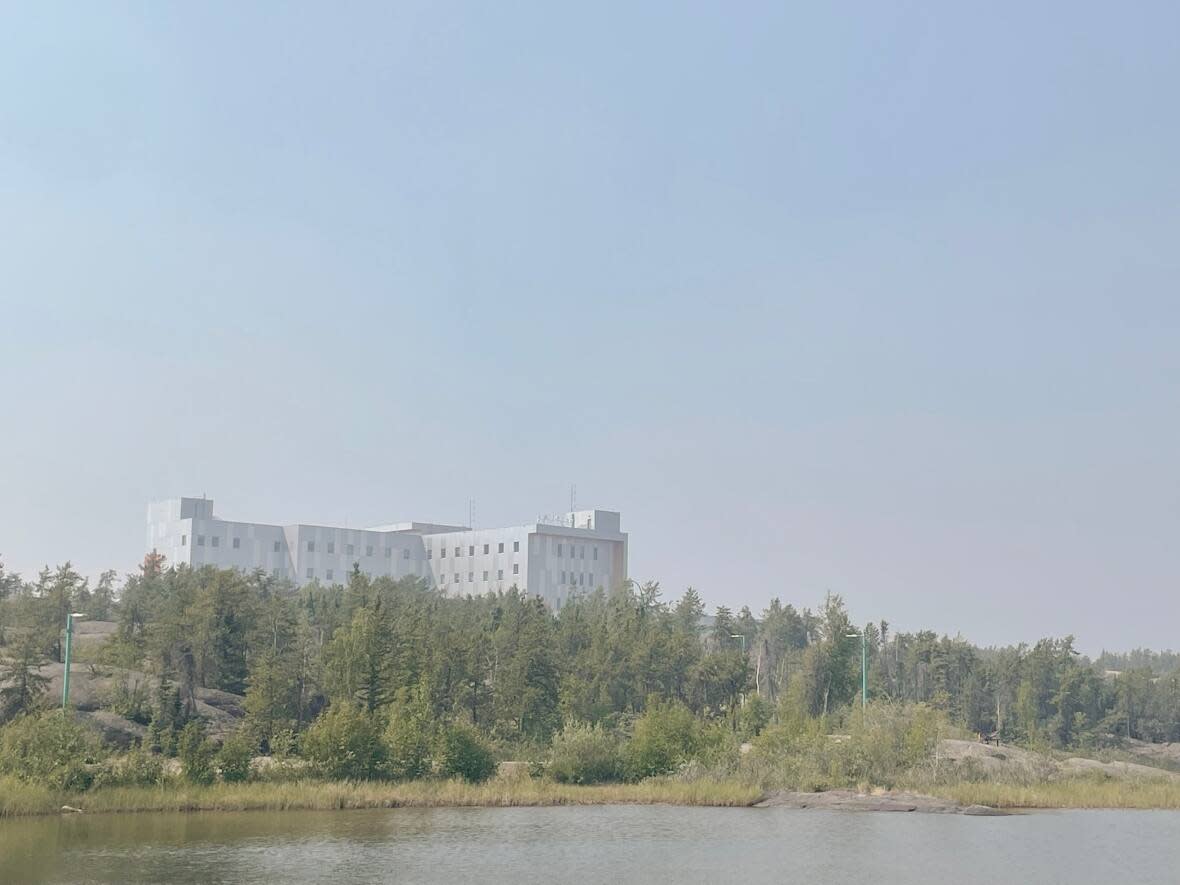 The Stanton Territorial Hospital as seen from the Frame Lake Trail through wildfire smoke in Yellowknife on Tuesday.  (Walter Strong/CBC - image credit)