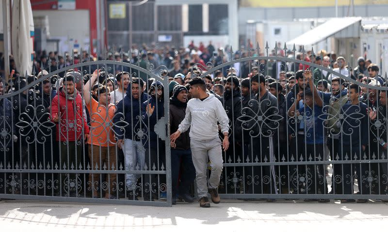 Migrants break through a fence as they protest in front of the refugee camp Miral in Velika Kladusa