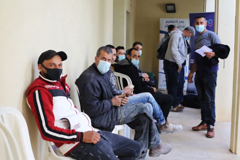 Palestinian labourers who work within Israel or its settlements in the occupied West Bank, wait to be vaccinated at an Israeli facility at Shaar Efraim crossing from Israel to the West Bank