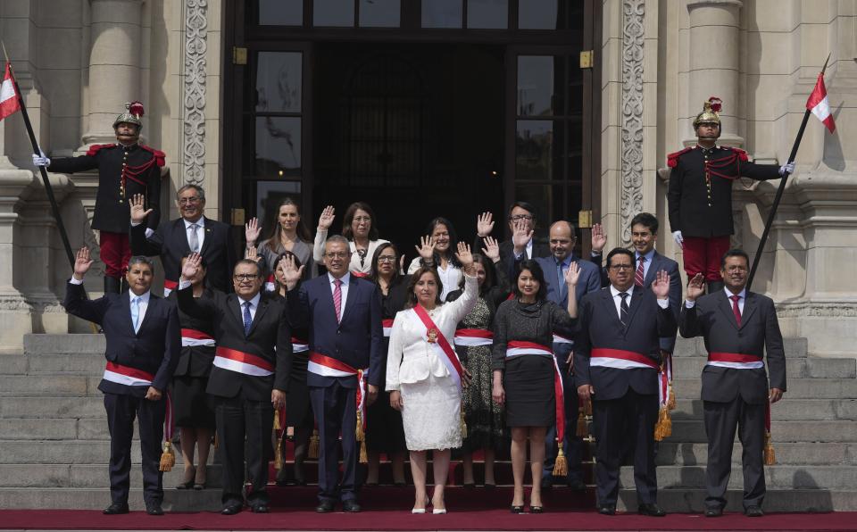 Peruvian President Dina Boluarte, center front, and newly named cabinet members wave as they pose for a group photo after their swearing-in ceremony, on the steps of the government palace in Lima, Peru, Saturday, Dec. 10, 2022. (AP Photo/Guadalupe Pardo)