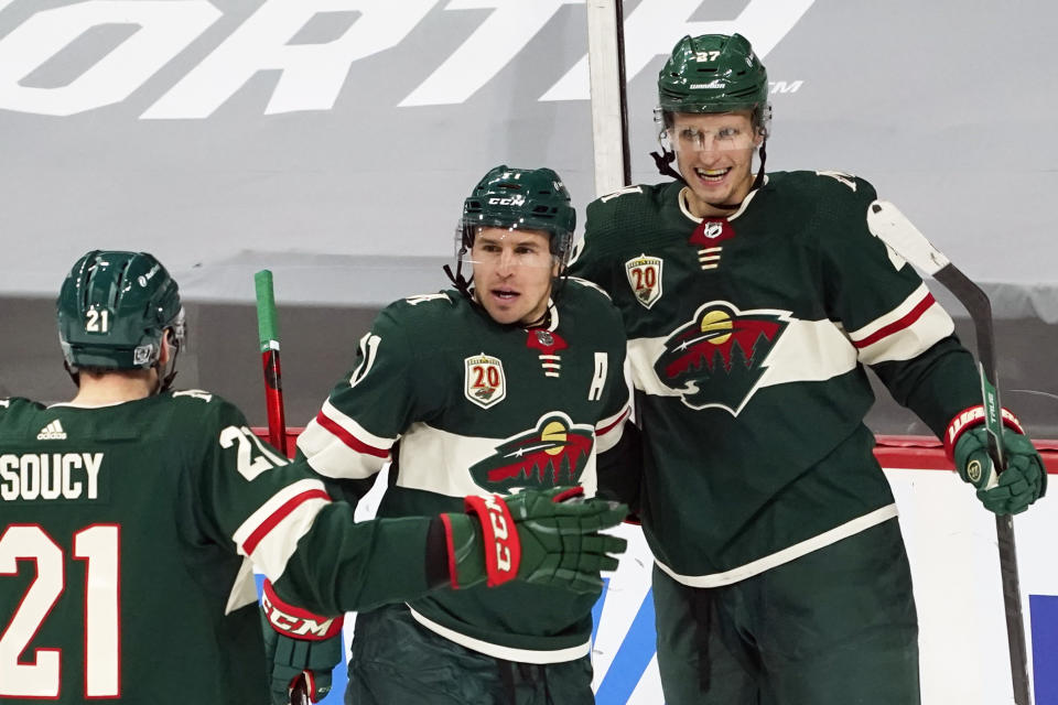 Minnesota Wild's Zach Parise, center, is congratulated by Minnesota Wild's Carson Soucy, left, and Nick Bjugstad after Parise scored against San Jose goalie Devan Dubnyk in the second period of an NHL hockey game, Friday, Jan. 22, 2021, in St. Paul, Minn. (AP Photo/Jim Mone)