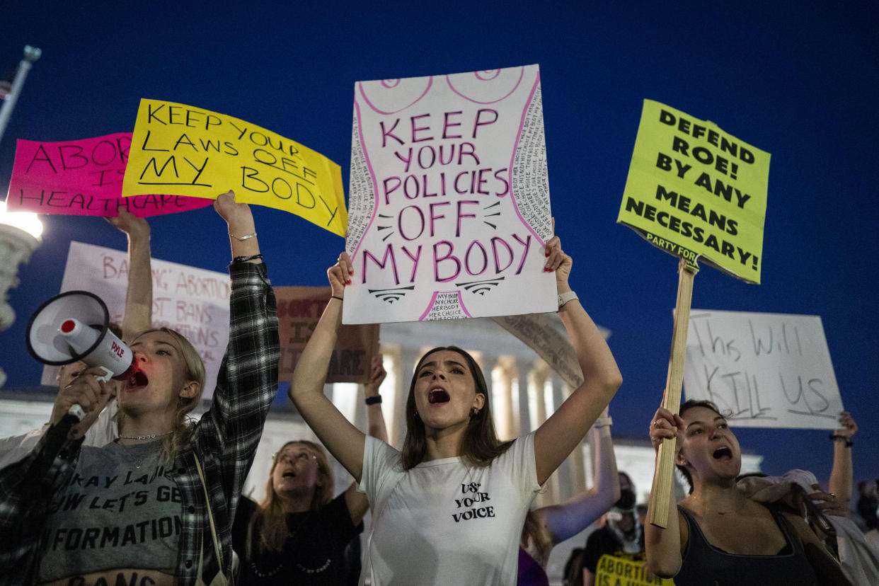 Abortion rights demonstrators hold up signs reading: Keep your laws off my body.
