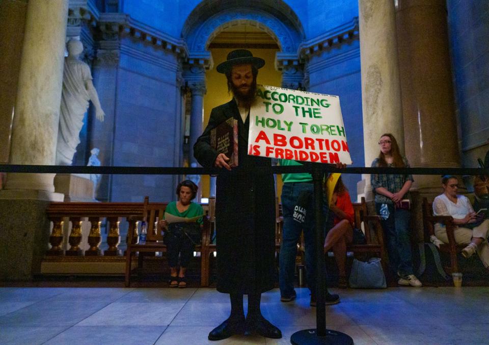 Moses Hirsch, of Centerville, Indiana, prays and holds a sign Tuesday, Aug. 2, 2022, just outside House Chambers at the Indiana Statehouse. Hirsch said he wanted to be at the Statehouse to represent the Jewish faith. Hirsch's views represent one of many in the Jewish community, which hosts a full range of opinions on the abortion rights debate.