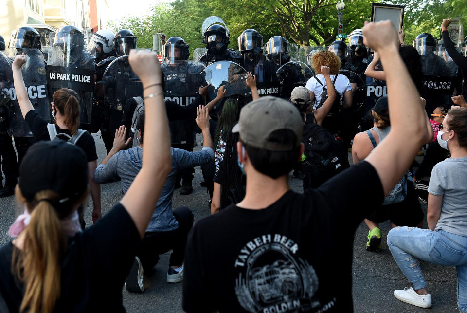 Protesters kneel and hold up their hands in front of a row of police during a demonstration against police brutality at a park near the White House on June 1 in Washington, D.C. (Photo: OLIVIER DOULIERY via Getty Images)