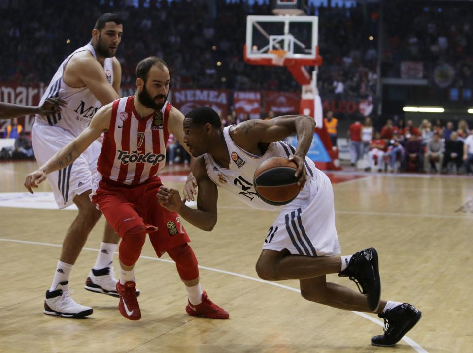 Olympiakos' Vassilis Spanoulis, center, defends as Real Madrid's Tremmell Darden, right, goes to score and Ioannis Bourousis looks on during a Euroleague playoff game 3 basketball match at the Peace and Friendship Arena in Athens' port of Piraeus on Monday, April 21, 2014. (AP Photo/Thanassis Stavrakis)