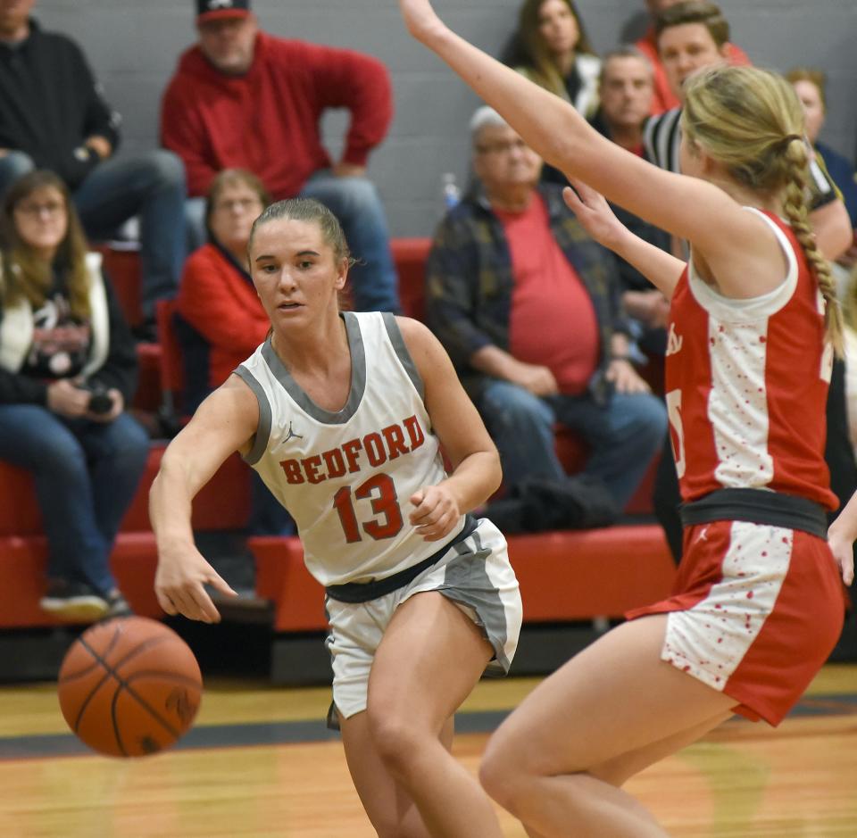 Payton Pudlowski of Bedford passes the ball inside past Monroe's Zoe Leach. Bedford won 55-33 in the semifinals of the Division 1 District at Bedford on Wednesday, March 6, 2024.