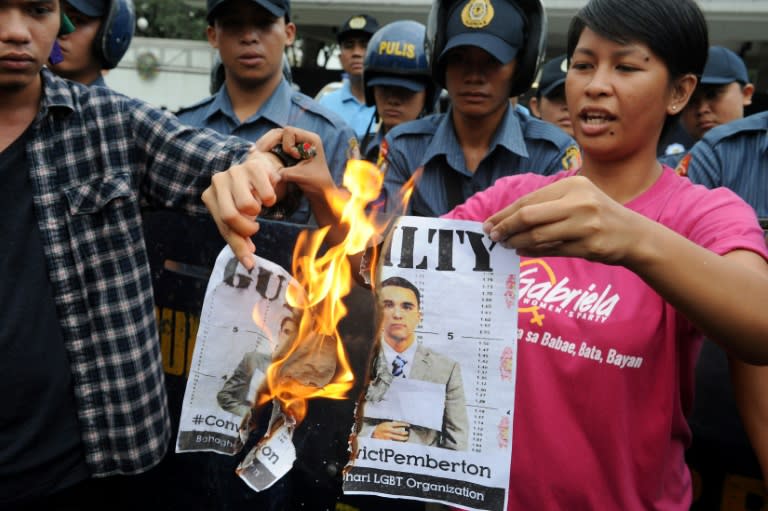 Filipino protesters burn a picture of US Marine Joseph Scott Pemberton -- who was convicted of killing a Filipina transgender woman -- as they demonstrate outside the US Embassy in Manila on December 1, 2015