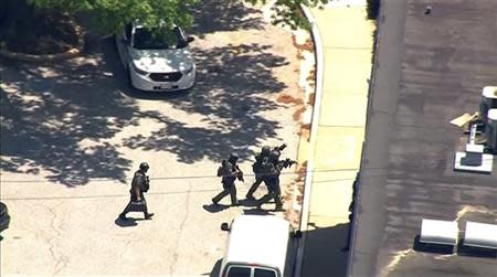 Police tactical team members arrive outside the ABC 2 news station after a possibly armed suspect crashed a vehicle into the Maryland television news station and barricaded himself inside the building, in Towson, Maryland, in this still image taken from video on May 13, 2014. REUTERS/Courtesy-WBAL-TV/Handout via Reuters