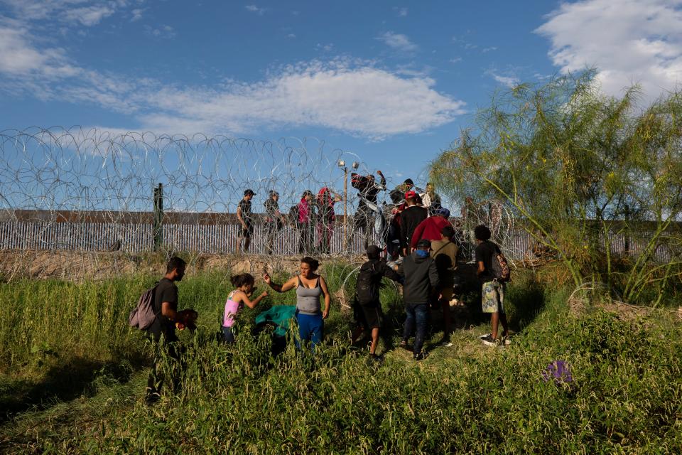 Migrants breach concertina wire installed by the Texas National Guard at the border between Juárez and El Paso on Sept. 20. U.S. Homeland Security Secretary Alejandro Mayorkas said there is "an acute and immediate need to construct physical barriers" at the border.